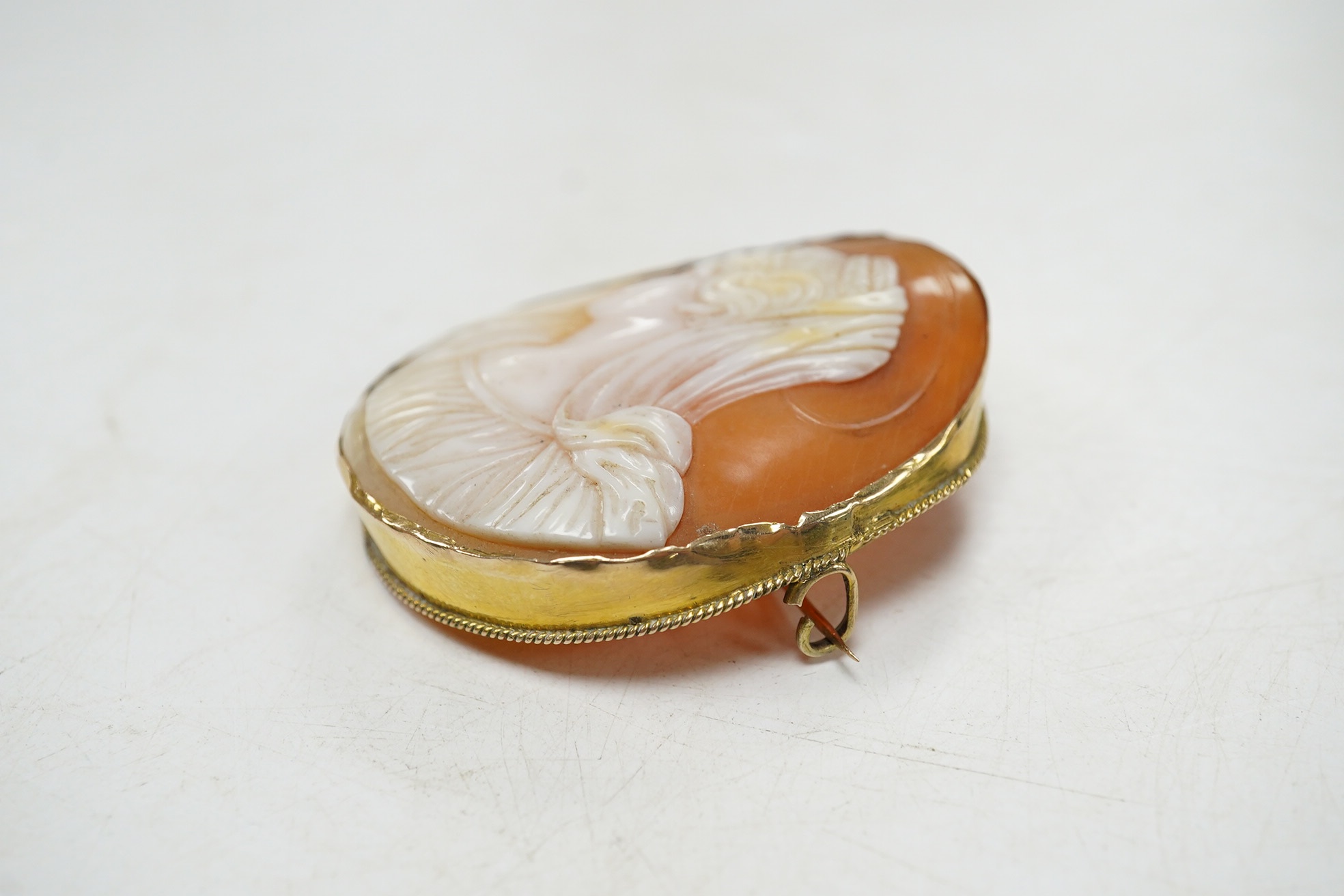 A yellow metal mounted oval cameo shell brooch, carved with the bust of a lady to dexter, 45mm. Condition - fair